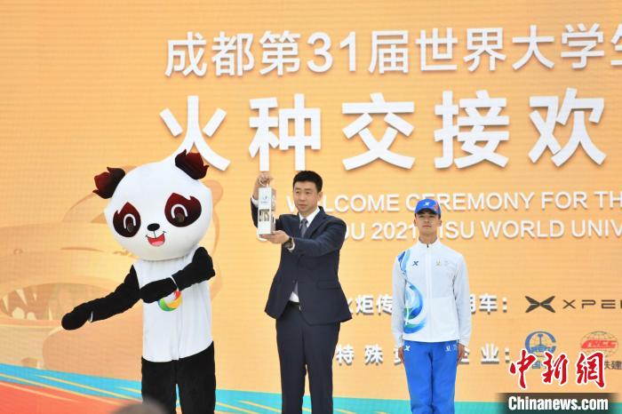 国际大体联副主席申震(中)将今年1月在首届大运会举办城市意大利都灵采集的火种递交给成都。 张浪 摄 国际大体联副主席申震(中)将今年1月在首届大运会举办城市意大利都灵采集的火种递交给成都。 张浪 摄