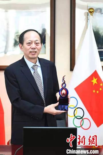 苟仲文接受利昂斯代表美奥委会赠予的荣誉奖杯 田彤桂 供图 苟仲文接受利昂斯代表美奥委会赠予的荣誉奖杯 田彤桂 供图